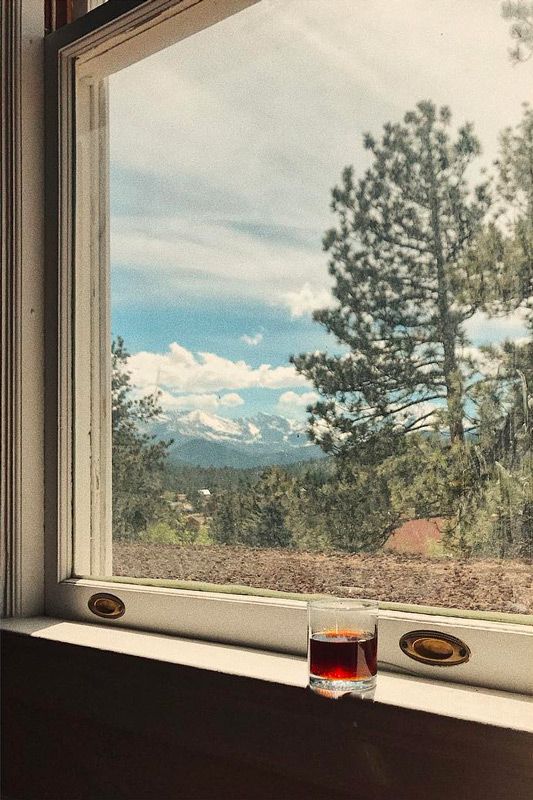 cocktail set in the window with snowey mountains in the background