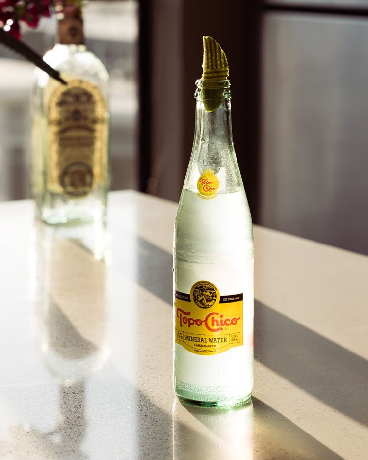 cold bottle of topo chico with a lime on top